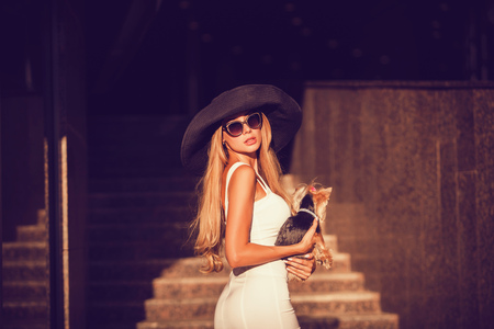 young fashion woman in the city with her dogの写真素材