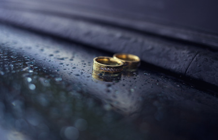 Wedding rings with jewel stones on a blue backgroundの写真素材