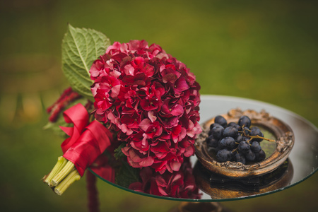Wedding bouquet and grapes lying on glass tableの写真素材