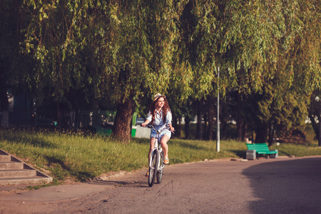 Woman riding bicycle in summer day. Copy spaceの写真素材