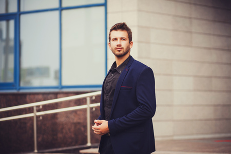 handsome successful manager in a suit. Portrait of a businessman near the officeの写真素材