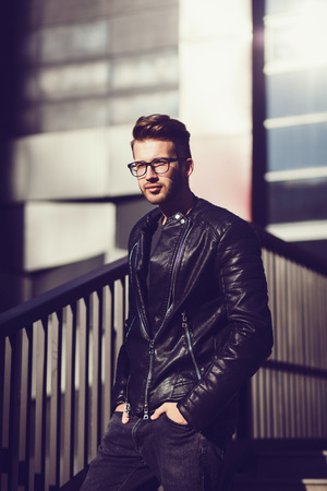Portrait of a stylish man with glasses and a leather jacketの写真素材