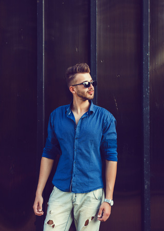 handsome young man standing near wallの写真素材