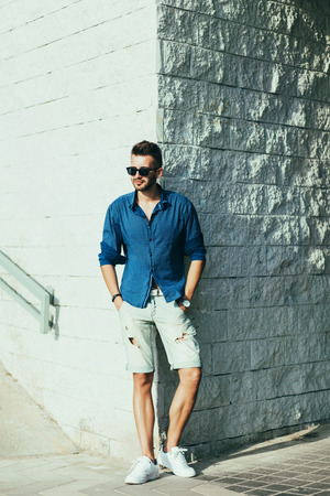 Stylish fashion man posing in shorts and shirtの写真素材