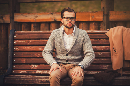 young man sitting on a bench in the parkの写真素材