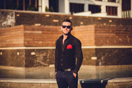 stylish young man in sunglasses standing and looking at the camera. copyspaceの写真素材