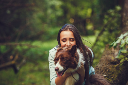 Portrait of happy girl and dog outdoorsの写真素材
