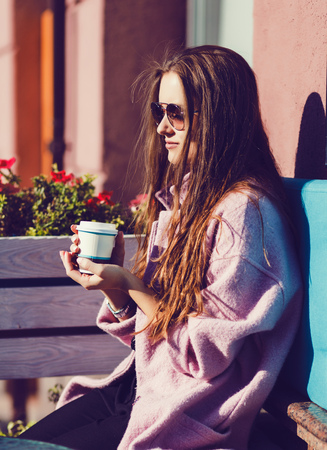 Beautiful fashion woman holding coffee cup and smilingの写真素材