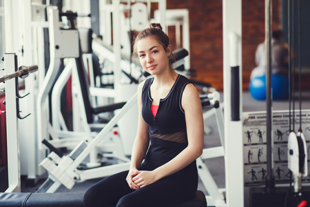 Sportive girl sitting in fitness gym.の写真素材