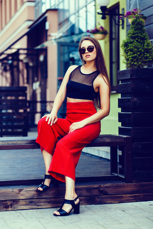 Beautiful stylish woman sitting in the city. Fashion imageの写真素材