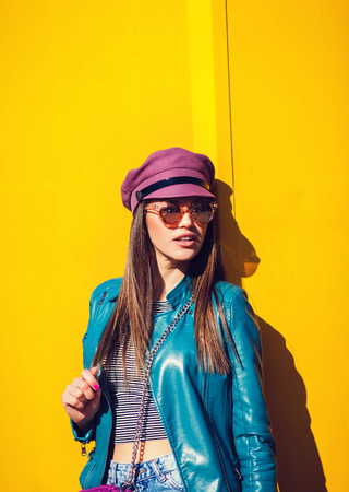 Young beautiful woman in leather jacket on yellow backgroundの写真素材
