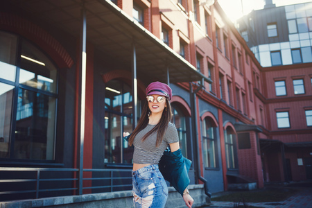 fashion model with long hair wearing sunglasses posing outdoor. Jeans, leather jacket, hatの写真素材