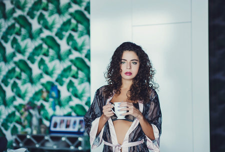 cute curly girl with mug of coffee in sexy clothes