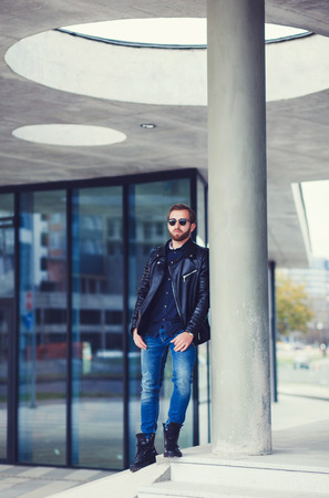 Man standing in street wearing black leather jacketの写真素材