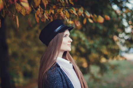 Pretty woman in autumn day. Lovely brunette woman in coat and hatの写真素材