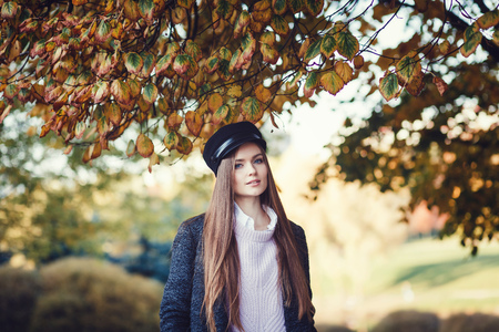 Happy lifestyle portrait of a beautiful young girl in autumn parkの写真素材