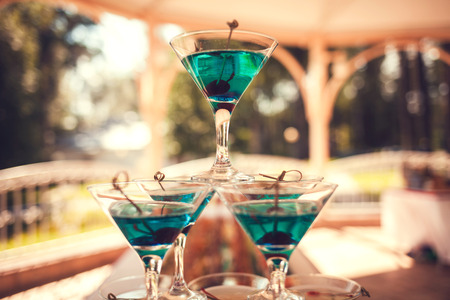pyramid of martini glasses with green olives on the barの写真素材