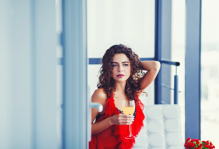 Portrait of young happy cheerful beautiful woman with glass of wineの写真素材
