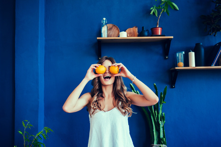 Emotional woman holding oranges in her hands. Minimalistic style. Stylish Trendyの写真素材