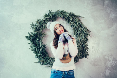 Beautiful woman in warm clothing on christmas tree background. Very beautiful girl in hat.の写真素材