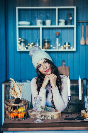 Happy young woman in christmas sitting in kitchenの写真素材