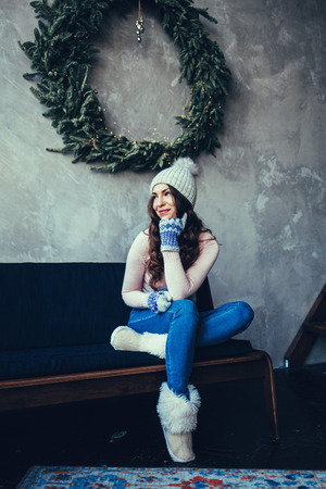 Happy young lady sitting on coach. New year concept.の写真素材