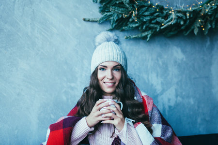 Cheerful woman in hat drinking morning coffee. Christmas concertの写真素材