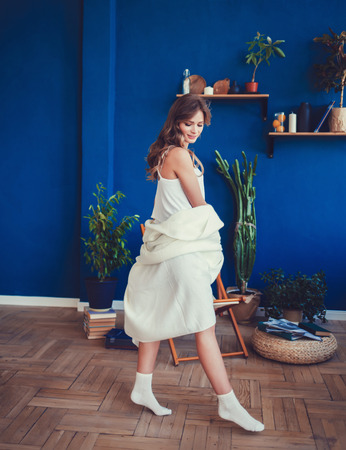 full height portrait of a woman with long hair in a bright interiorの写真素材