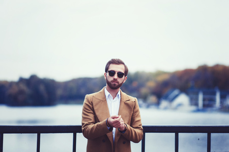 portrait of a fashion model, man wearing coat and sunglassesの写真素材