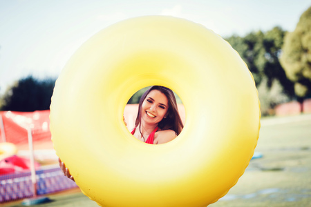 Tropical summer holiday fashion concept - tanning woman smiling holding inflatable circleの写真素材