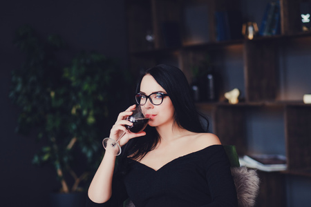 young gorgeous brunette girl with glass of red wineの写真素材