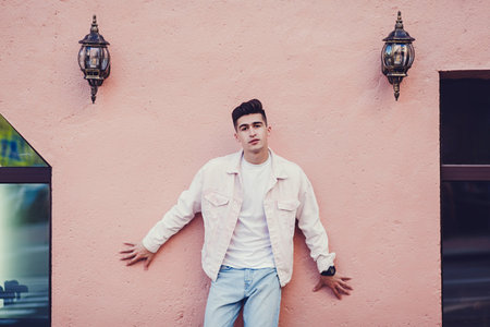 Handsome male model wearing white t-shirt and jacket with space for your logo or design in casual urban styleの写真素材