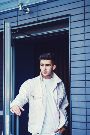 Portrait of a handsome young man in jeans and white jacketの写真素材