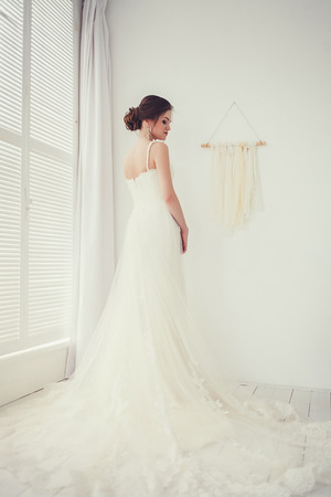 Beautiful bride in wedding dress in light roomの写真素材