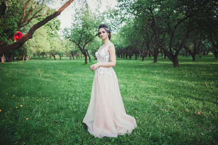full-length portrait of the bride in a glamorous wedding dress outdoorsの写真素材