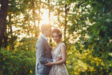 Sunshine portrait of happy bride and groom outdoor in nature location at sunset.の写真素材