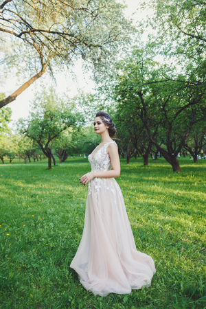 The stunning young bride is incredibly happy. A beautiful bride portrait in the park.の写真素材