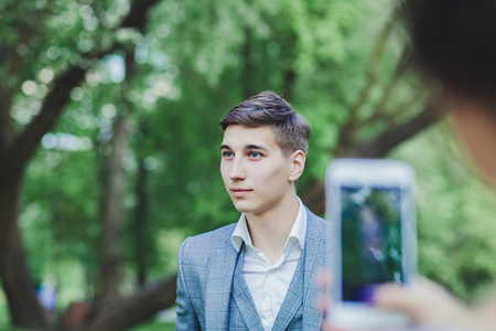bride takes pictures of the groom in the park. wedding dayの写真素材