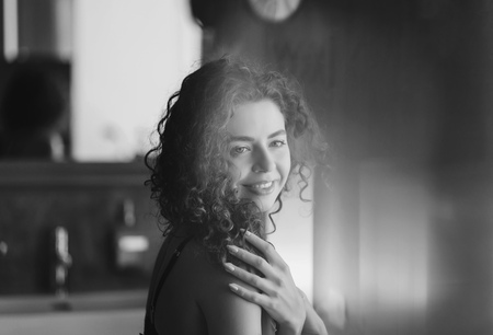 Beautiful fashion girl. Portrait of young happy curly woman in black and whiteの写真素材