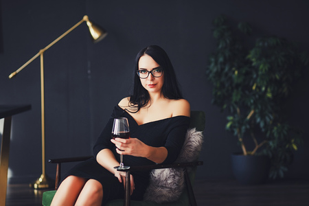 Beautiful woman with wine glass and black dressの写真素材