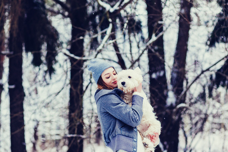 wonderful woman hugging a dog in a winter parkの写真素材