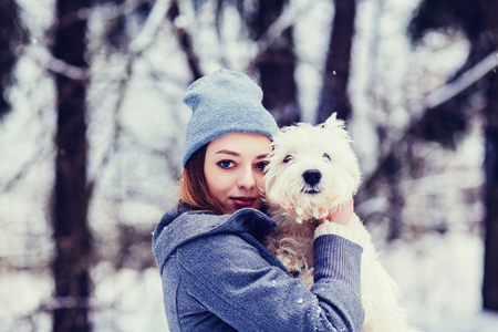 Portrait of a beautiful woman hugging her dog outdoorsの写真素材