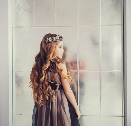 Beautiful little girl with long wavy hair wearing dressの写真素材