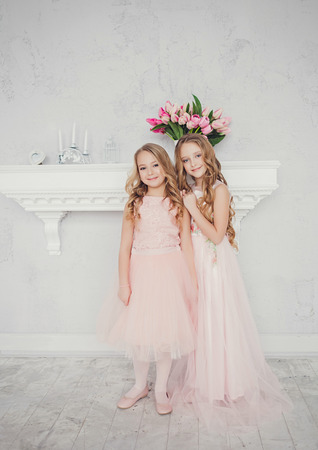 Fashion little sisters posing in the studioの写真素材
