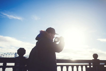 man photographs the city on a sunny winter dayの写真素材