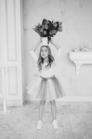 black and white portrait of a little princess girl with a bucket of tulipsの写真素材