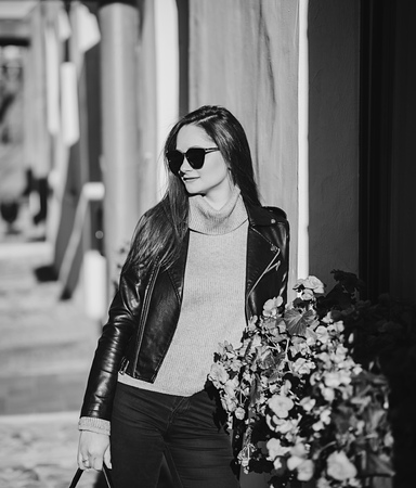 black and white portrait of fashionable woman in glasses and leather jacketの写真素材
