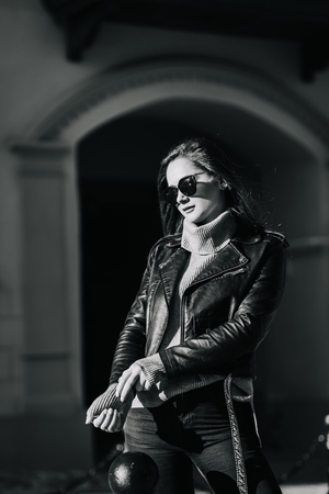 stylish portrait of a young woman in sunglasses and leather jacketの写真素材