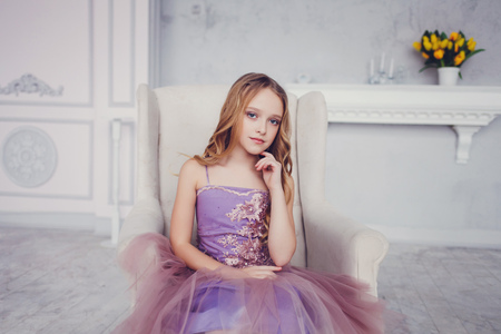 beautiful little girl in a chic dress sitting in the studioの写真素材