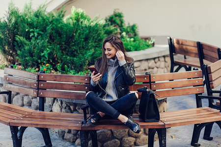 Stylish woman listening music on city street. Copyspaceの写真素材